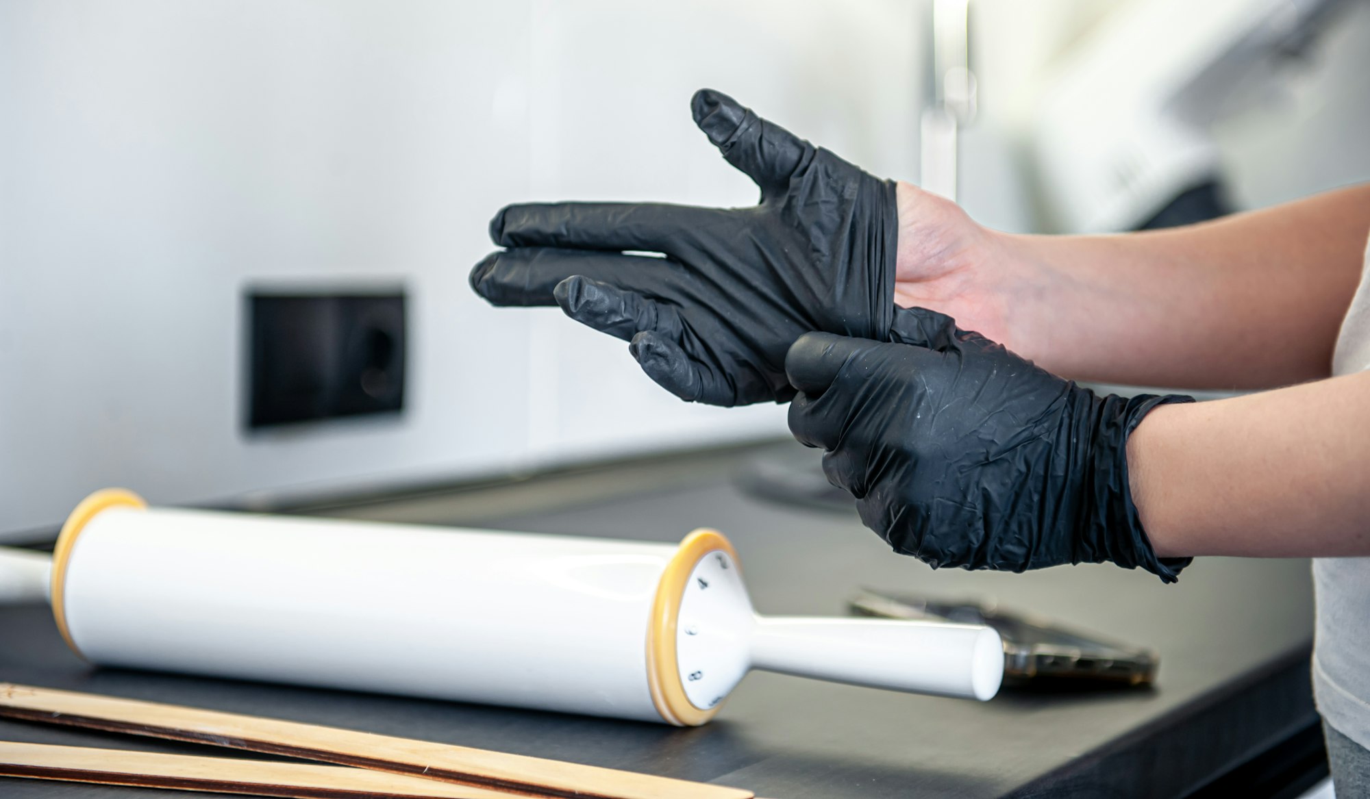 A woman puts on gloves in the kitchen, kitchen work and hygiene.